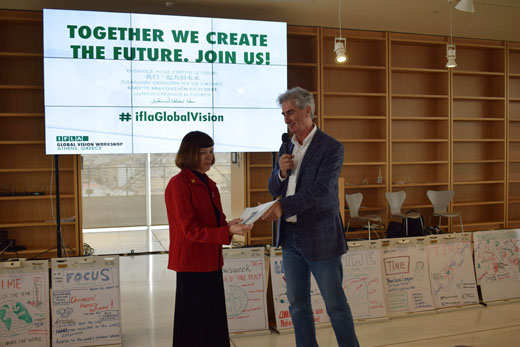 IFLA Secretary General Gerald Leitner hands IFLA President Donna Scheeder a draft summary report on the Global Vision Discussion