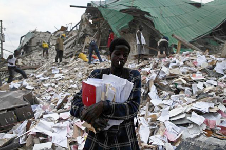 A man retrieving documents from the rubble