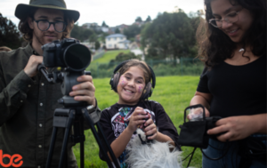 Shaniece from Empathy - picture of a child with face paint working with a film crew, smiling